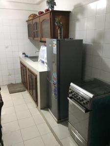 a kitchen with a refrigerator and a stove at Chez Jamila in Dakar