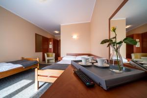 a room with two beds and a table with a remote control at Willa Horn in Władysławowo +139 photos