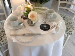 een tafel met een wit tafelkleed en bekers en een mes bij Lamaison du phare honfleur chambres d'hotes in Honfleur