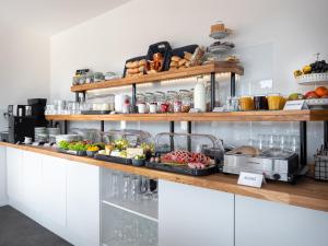 uma cozinha com um buffet de comida num balcão em Hotel das Q em Aldingen