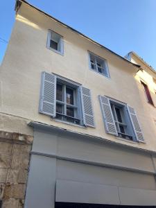 a building with three windows with shutters on it at Le celebrity in Agen +3 photos