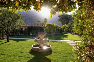 a stone fountain in the middle of a lawn at The Colony Palms Hotel and Bungalows - Adults Only in Palm Springs