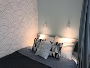 a bedroom with a bed with two pillows and a wall at Apartament Blisko Morza i Parku Gdańsk Brzeźno in Gdańsk