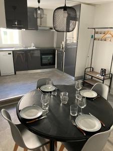 una mesa negra con platos y vasos en ella en una cocina en L'impressionnisme, en Agen