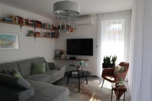 ein Wohnzimmer mit einem Sofa und einem TV in der Unterkunft Fűzi-Lizi Apartman in Balatonfůzfő