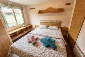 ein Schlafzimmer mit einem Bett mit zwei Handtüchern darauf in der Unterkunft Mobilheim Atlas Villa V. - Výrovická přehrada in Znojmo