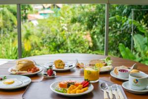 a table topped with plates of breakfast foods and drinks at Pousada do Tenório in Ubatuba +48 photos