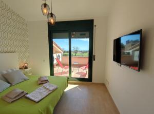 Bonmont Terres NovesにあるPreciosa Casa Con Piscina En Bonmontのベッドルーム(緑のベッド1台、薄型テレビ付)