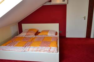 Bett mit orangefarbener und weißer Bettwäsche in einem Zimmer in der Unterkunft Loft Apartments Pulheim in Pulheim