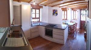 a kitchen with white cabinets and a black counter top at Apartments Ban Guggugg in Colle Isarco