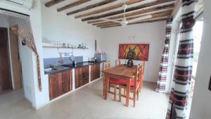 a kitchen with a wooden table and a sink at Maisha Marefu Apartments in Kiwengwa