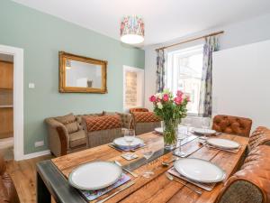 a dining room with a wooden table with flowers on it at Gairnlea House in Ballater