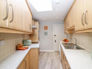 a kitchen with wooden cabinets and a sink at Gairnlea House in Ballater +15 photos