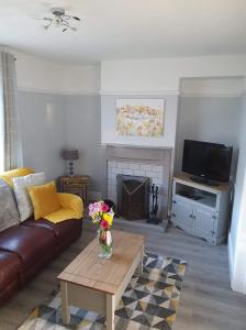 a living room with a couch and a table with flowers at Seahouses cottage in Seahouses