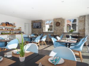 une salle à manger avec des tables et des chaises bleues dans l'établissement Hotel das Q, à Aldingen