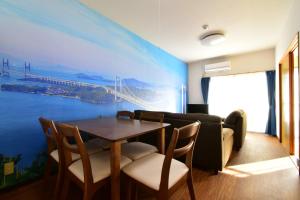 a dining room with a large painting on the wall at Maison Ota Building A Building B - Vacation STAY 11139 in Takamatsu