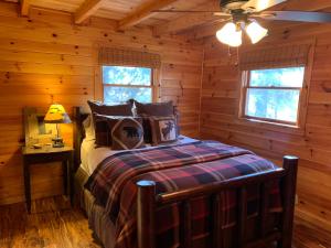 a bedroom with a bed in a log cabin at Lickskillet Lodge on Fightingtown Creek; HOT TUB in Blue Ridge