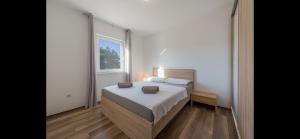sypialnia z łóżkiem i oknem w obiekcie Aurum luxury apartments w mieście Vir