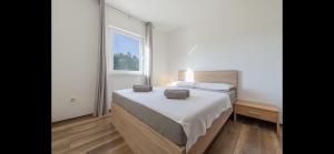 sypialnia z łóżkiem i dużym oknem w obiekcie Aurum luxury apartments w mieście Vir