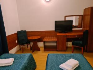 Habitación con escritorio, cama y espejo. en Pokoje gościnne Restauracji Don Roberto, en Frombork