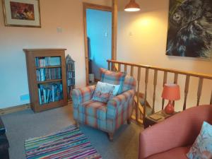 ein Wohnzimmer mit einem Stuhl und einem Bücherregal in der Unterkunft Bank End in Egremont