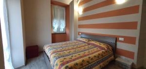 ein Schlafzimmer mit einem Bett mit gestreifter Wand in der Unterkunft La Casa degli Archi in Tavarone
