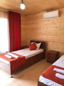 1 dormitorio con 2 camas en una cabaña de madera en Cottage and Gigo Papa's Wine Cellar en Kvareli