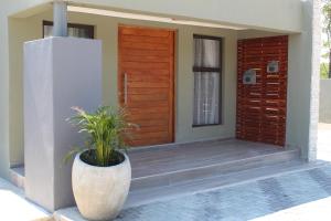 una porta d'ingresso di una casa con una pianta di Villa 13 Maun a Maun