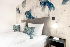 Un dormitorio con una cama y una pared con pájaros. en Haus Dikhus en Rantum