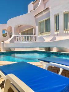 een gebouw met een zwembad voor een huis bij Villa Amendoeiras 52 in Albufeira