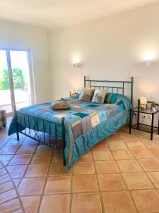 Schlafzimmer mit einem Bett mit blauer Decke in der Unterkunft Villa Amendoeiras 52 in Albufeira