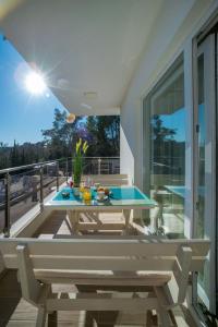 eine Terrasse mit einem Tisch und einem Pool auf dem Balkon in der Unterkunft HAPPY HOME in Tivat