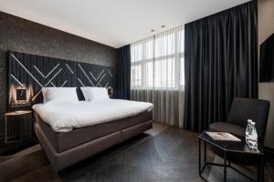 a hotel room with a bed and a chair at Le Marin Boutique Hotel in Rotterdam