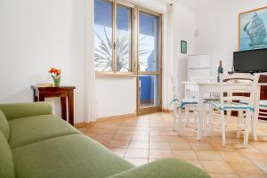 a living room with a couch and a table and chairs at Appartamenti Lungoni in Santa Teresa Gallura