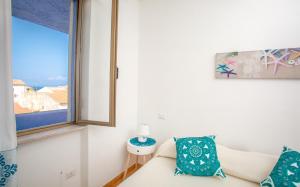 un soggiorno con divano e finestra di Appartamenti Lungoni a Santa Teresa di Gallura