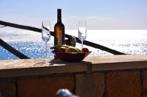 a bowl of fruit and a bottle of wine and glasses at Coral Front Beach in Kato Zakros