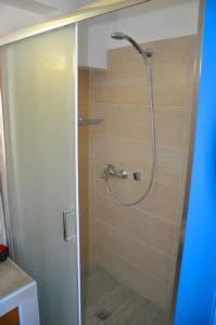 a shower with a glass door in a bathroom at Coral Front Beach in Káto Zákros