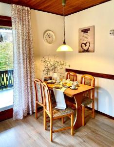 a dining room with a table and chairs and a clock at Ferienhäuser Pannier III und IV Doppelhaushälften in Gartow