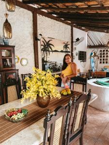 a woman standing at a table in a kitchen at Pousada dos Candeeiros in Carolina