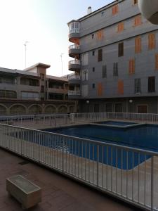 - un bâtiment avec une piscine à côté d'un bâtiment dans l'établissement Naufragos Apartament Torrevieja, à Torrevieja