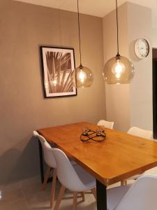 - une table à manger avec des chaises blanches et des lumières dans l'établissement Naufragos Apartament Torrevieja, à Torrevieja