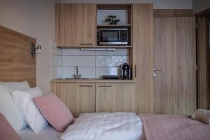 kuchnia z kuchenką mikrofalową i łóżko w pokoju w obiekcie Rácz Vendégház w mieście Sopron +36 zdjęć