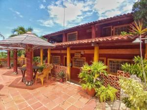 Casa da Lua في جاكوما: منزل به فناء مع طاولة ومظلة