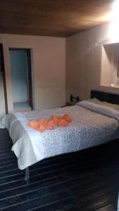 una camera da letto con un letto con sopra dei vestiti arancioni di Posada Santa María a Mineral del Chico