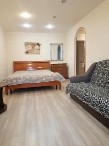 a bedroom with a bed and a couch at проспект металлургов 9 in Kryvyi Rih