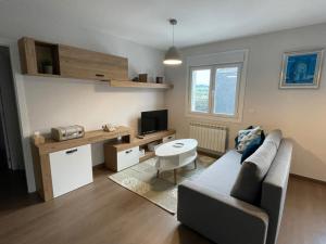 una pequeña sala de estar con sofá y TV en Alojamientos con encanto Ruliña en Portomarin