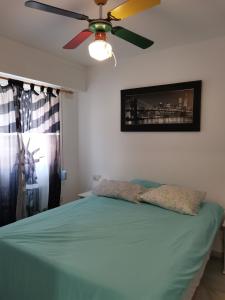 a bedroom with a ceiling fan and a green bed at Apartamento con wifi, mascotas bienvenidas in Benidorm +20 photos