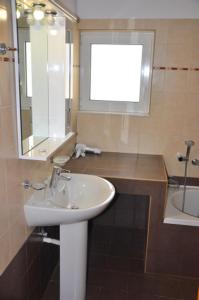 a bathroom with a sink and a mirror and a tub at Alkioni Sea View Apartment in Kato Zakros