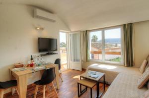 een woonkamer met een bank en een tafel met stoelen bij Appartement 2 pièces Pied dans l'eau in Porto-Vecchio
