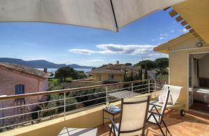 Un balcón con 2 sillas y una mesa con vistas. en Appartement 2 pièces Pied dans l'eau, en Porto Vecchio